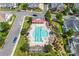 Aerial view of the community pool with lounge chairs, landscaping, and a clubhouse at 15209 Loire Valley St, Charlotte, NC 28277