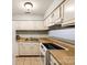 Cozy kitchen with white appliances and cabinetry, tiled flooring and a butcher block countertop at 1606 Sharon W Rd # 40, Charlotte, NC 28210