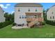 Spacious backyard featuring a wooden deck with pergola, a stone patio with fire pit, and lush greenery perfect for outdoor living at 17231 Rider Wood Ln, Charlotte, NC 28278