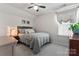 Well-lit bedroom with neutral colors, cozy bedding, ceiling fan, and side table with lamp at 17231 Rider Wood Ln, Charlotte, NC 28278