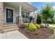 Charming front porch with brick columns, black railing, and landscaped garden, creating an inviting entrance to the home at 17231 Rider Wood Ln, Charlotte, NC 28278