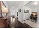 Bright hallway featuring hardwood floors, an archway leading to a living room, and access to a private office space at 17231 Rider Wood Ln, Charlotte, NC 28278