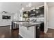 Island kitchen boasts black cabinets, stainless appliances, granite countertops, and pendant lights at 17231 Rider Wood Ln, Charlotte, NC 28278