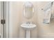 Powder room features pedestal sink, oval mirror, and towel bar at 1825 Evergreen Dr, Charlotte, NC 28208