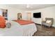 Bedroom features wood floors, ceiling fan, large dresser, and grey chair at 1825 Evergreen Dr, Charlotte, NC 28208