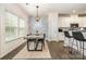 Well-lit dining area featuring a modern table setting and smooth transition to the kitchen and living room at 1825 Evergreen Dr, Charlotte, NC 28208