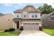 Charming two-story home features a two-car garage, neat landscaping, and a welcoming front entrance at 1825 Evergreen Dr, Charlotte, NC 28208