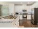 Bright kitchen features white cabinets, granite counters, stainless steel appliances, and hardwood floors at 1825 Evergreen Dr, Charlotte, NC 28208