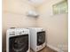Convenient laundry room with a washer, dryer, and overhead storage shelves at 1825 Evergreen Dr, Charlotte, NC 28208