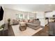 Comfortable living room featuring plush seating, neutral decor, and seamless flow to the dining area at 1825 Evergreen Dr, Charlotte, NC 28208