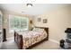 Bright bedroom featuring a floral patterned bedspread, neutral walls, and a large window for natural light at 1846 Sam Smith Rd, Fort Mill, SC 29708