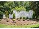 Welcome to Sutton Place! Elegant white brick community sign surrounded by lush landscaping and greenery at 1846 Sam Smith Rd, Fort Mill, SC 29708