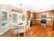 Eat-in kitchen with wooden cabinetry, stainless appliances, hardwood floors, and a bay window at 1846 Sam Smith Rd, Fort Mill, SC 29708