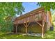 Brick home with a wood deck featuring ample space underneath for yard equipment storage at 212 Foxfield Ln, Matthews, NC 28105