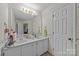 Charming bathroom features a double vanity, floral wallpaper, and a large mirror for added convenience at 212 Foxfield Ln, Matthews, NC 28105