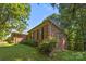 Brick home exterior with lush green lawn and large bushes at 212 Foxfield Ln, Matthews, NC 28105