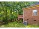 Brick home exterior with an attached deck surrounded by lush trees at 212 Foxfield Ln, Matthews, NC 28105