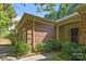 Brick home featuring a covered front entrance and attached garage, with mature landscaping at 212 Foxfield Ln, Matthews, NC 28105