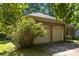 Double garage in a brick home with a large flowering bush in the front at 212 Foxfield Ln, Matthews, NC 28105