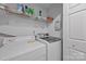 Efficient laundry room features a modern washer and dryer, with shelving for storage and organization at 212 Foxfield Ln, Matthews, NC 28105