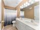 Bright bathroom featuring double sinks, white cabinets, and a shower with a curtain at 2240 Arbor Vista Dr, Charlotte, NC 28262