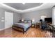 Bedroom features a tray ceiling, wood floor, and a dedicated workspace at 2240 Arbor Vista Dr, Charlotte, NC 28262
