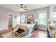 Bright bedroom with a bed, sitting bench, two windows and hardwood floors at 2619 Merion Hills Ct, Charlotte, NC 28269