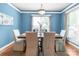 Dining room with blue walls, large windows, modern chandelier, and seating for six at 2619 Merion Hills Ct, Charlotte, NC 28269