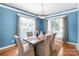 Dining room featuring blue walls, modern lighting, and large windows for natural light at 2619 Merion Hills Ct, Charlotte, NC 28269