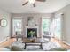 Cozy living room with a fireplace, hardwood floors, and large windows providing ample natural light at 2619 Merion Hills Ct, Charlotte, NC 28269