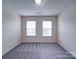 An empty bedroom showcases plush gray carpeting and natural light from two windows at 3009 Palm Dr, Fort Mill, SC 29715