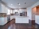 Bright kitchen boasts stainless appliances, a mosaic backsplash, granite counters, and dark wood floors at 3009 Palm Dr, Fort Mill, SC 29715