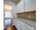 Walk-in pantry off kitchen with granite counters, mosaic backsplash, and white cabinets at 3009 Palm Dr, Fort Mill, SC 29715