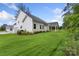 Manicured backyard featuring a covered porch, lush landscaping, and pristine green lawn at 3222 Player Ct, Salisbury, NC 28144