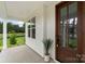 Inviting covered porch with a view of the beautifully landscaped front yard and a stylish wooden door at 3222 Player Ct, Salisbury, NC 28144
