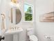 Chic powder room with a pedestal sink, round mirror, and natural light from the window at 3222 Player Ct, Salisbury, NC 28144