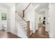 Elegant staircase with wooden handrail, white spindles, and hardwood floors at 3222 Player Ct, Salisbury, NC 28144