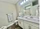 Bright bathroom with a double vanity, a framed mirror, modern fixtures, gray walls, and wood look floors at 325 Jordan Ave, Salisbury, NC 28159
