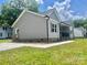Charming home with gray siding, wooden shutters, a black porch railing, a well-manicured lawn, and concrete pathway at 325 Jordan Ave, Salisbury, NC 28159