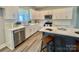 Bright kitchen with white cabinets, subway tile backsplash, stainless steel appliances, and center island with bar seating at 325 Jordan Ave, Salisbury, NC 28159