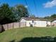 Wide angle of the home's backyard with well-kept grass, a shed and fence at 327 Downing St, Troutman, NC 28166