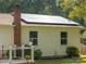 Charming home featuring modern solar panels, a brick chimney, and a well-maintained green yard at 327 Downing St, Troutman, NC 28166