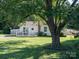Charming single-story home with a welcoming front porch, mature tree, and well-maintained lawn at 327 Downing St, Troutman, NC 28166