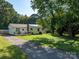 Attractive single-story home with a spacious yard, inviting front porch, and a private driveway at 327 Downing St, Troutman, NC 28166