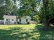 Cozy single-story home features a quaint porch, sunny lawn, and a mature tree offering shade at 327 Downing St, Troutman, NC 28166