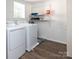 Practical laundry room with modern washer and dryer set, offering efficient functionality and storage shelves at 327 Downing St, Troutman, NC 28166