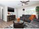 Bright living room with a large screen TV, comfortable seating, and modern flooring at 327 Downing St, Troutman, NC 28166