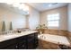 Bathroom with a double sink vanity, a granite countertop, and a soaking tub at 3537 Hornets Nest Way # 206, Charlotte, NC 28208