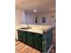 An open-concept kitchen with green cabinets and stainless steel sink is great for entertaining at 379 Sharpe St, Mooresville, NC 28115