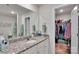 Bathroom with a granite countertop vanity, large mirror, and an open walk-in closet for organized storage at 410 Apex Cir, Shelby, NC 28152